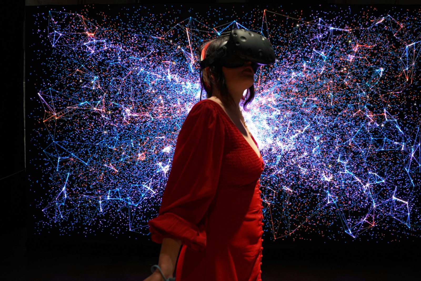 A woman in a red dress wearing a virtual reality headset