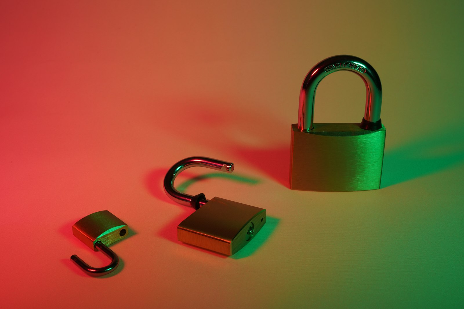 Green and silver padlock on yellow surface