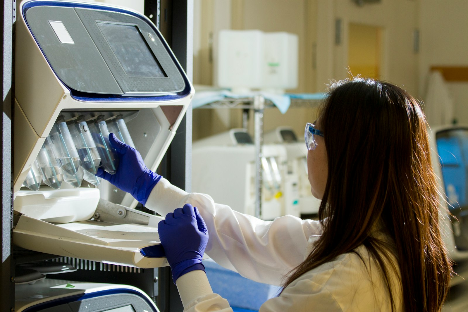 Woman in white long sleeve shirt wearing blue gloves