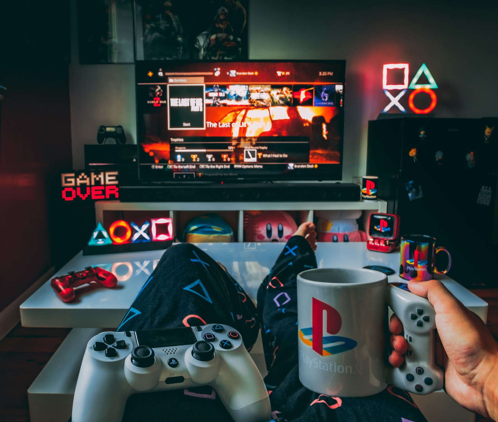 A person holding a cup and a game controller in front of a television