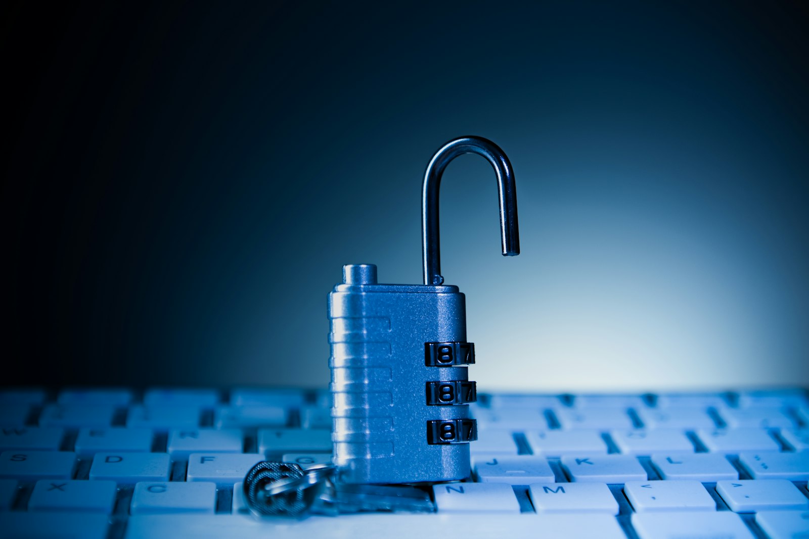 An unlocked padlock rests on a computer keyboard
