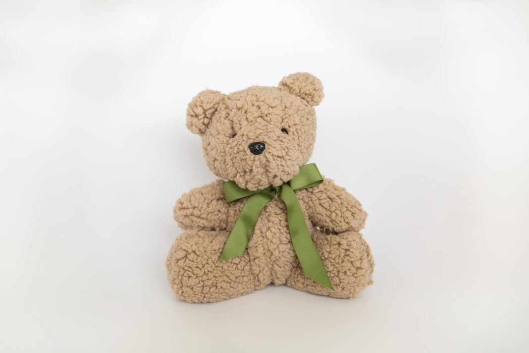 a stuffed bear with a green bow